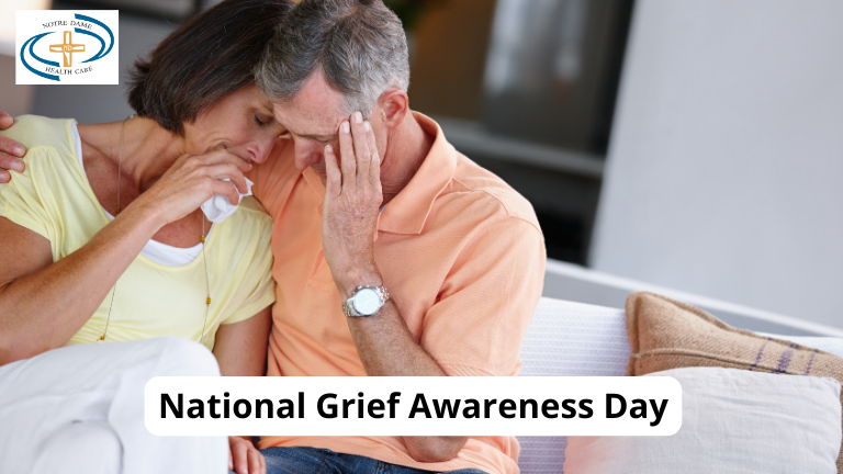 A man and woman hugging on a couch with the words national grief awareness day.